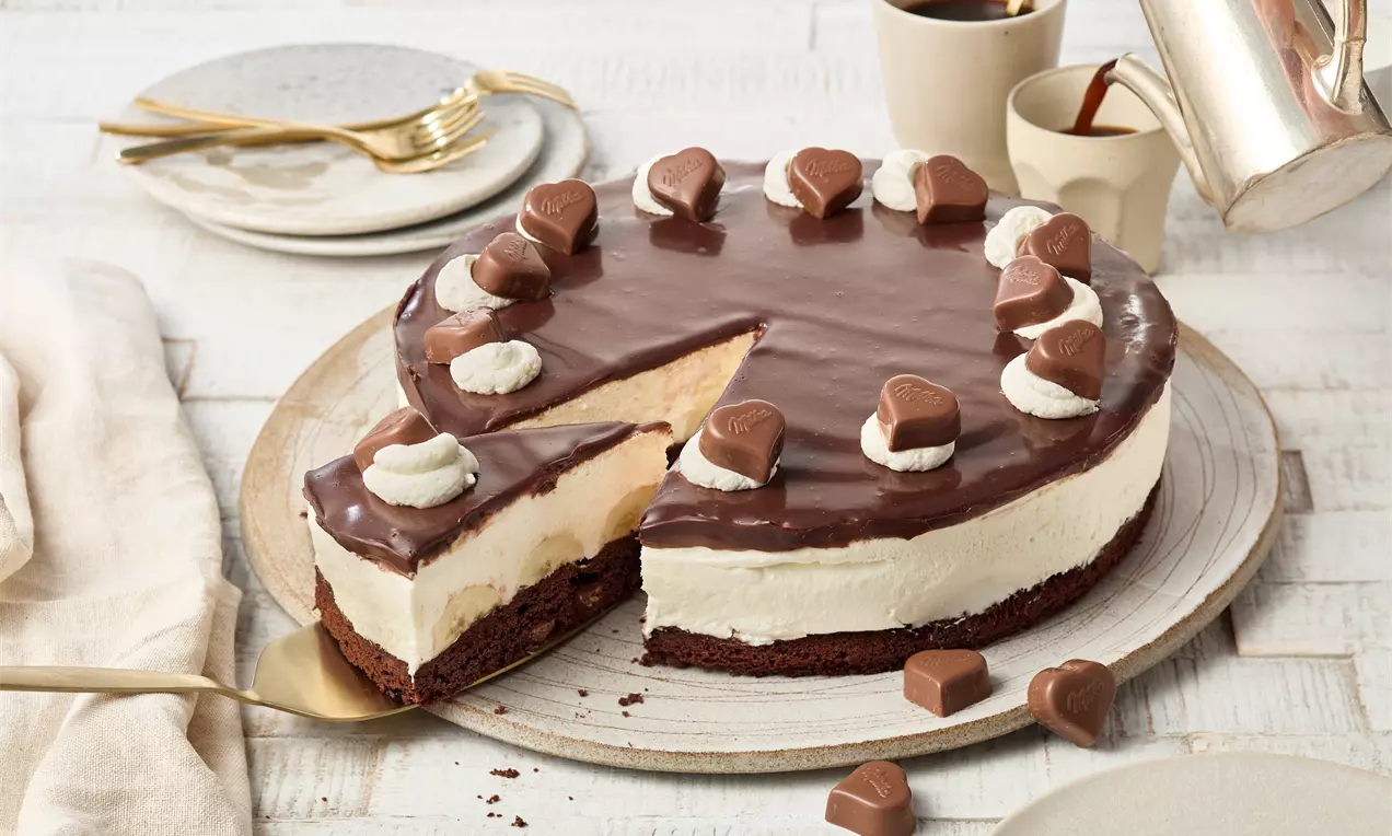 Milka®-Torte mit Schokoboden, Bananen, Joghurt-Sahne-Creme und Ganache – einfaches Rezept für eine cremige Schokoladentorte, ideal für Geburtstage, Feste oder besondere Anlässe.