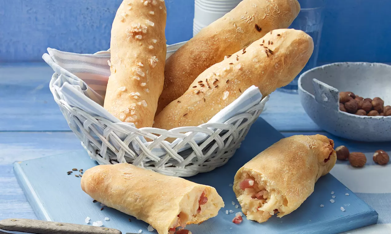 Schwäbische Seelen auf Holzbrett: goldbraune, längliche Brötchen mit grobem Salz, knuspriger Kruste und Butter