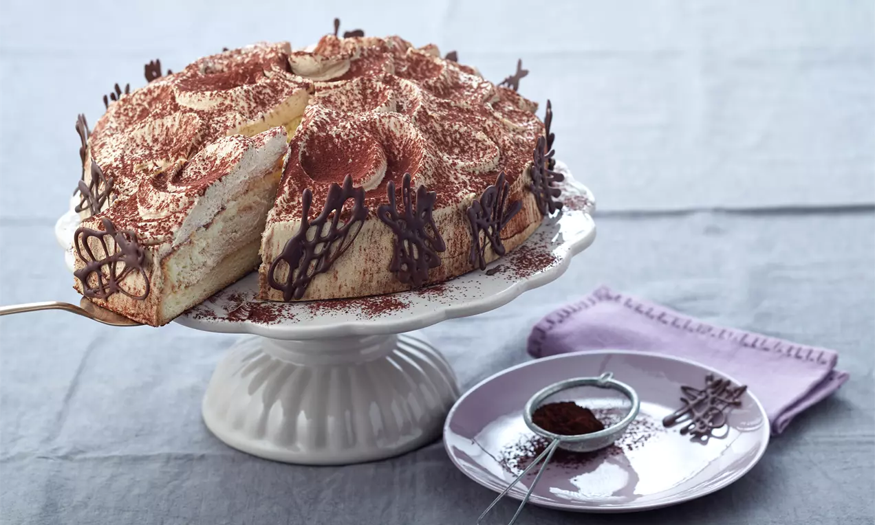 Cappuccino-Sahne-Torte mit kuppelförmiger Sahnecreme, hellbraunem Biskuitboden, Kakaostaub und Schokoladenraspeln