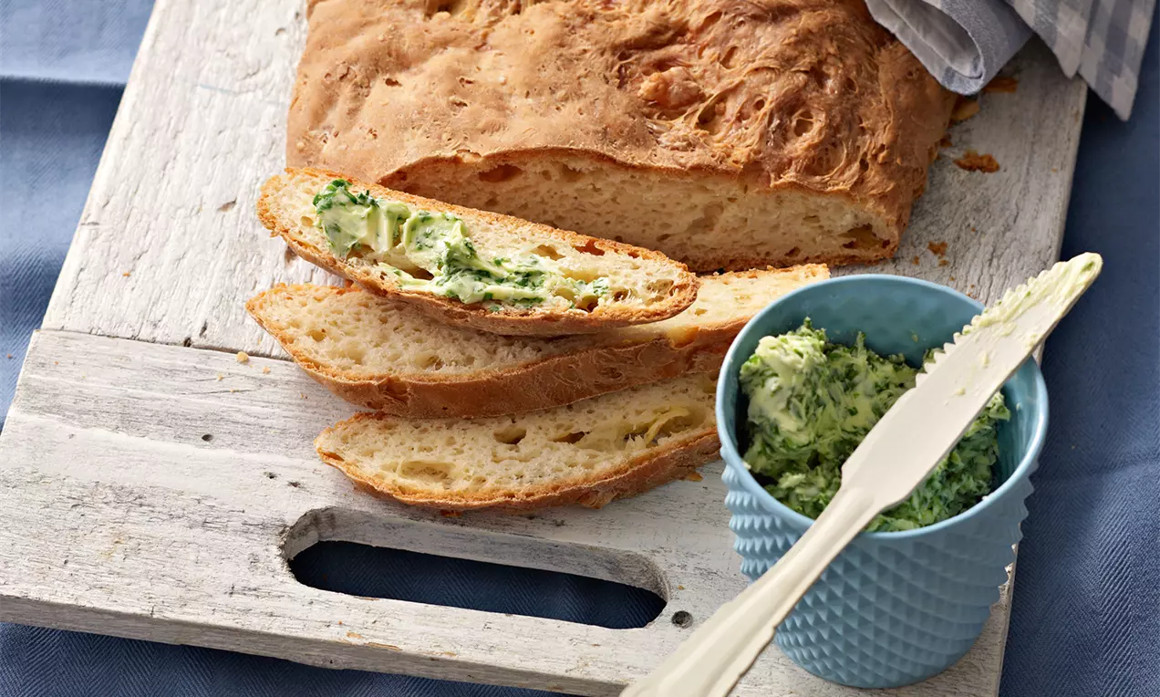 Käsebrot mit drei verschiedenen Käsesorten, goldbraunem Röstbrot, schmelzendem Gouda, würzigem Emmentaler und frischen Kräutern garniert