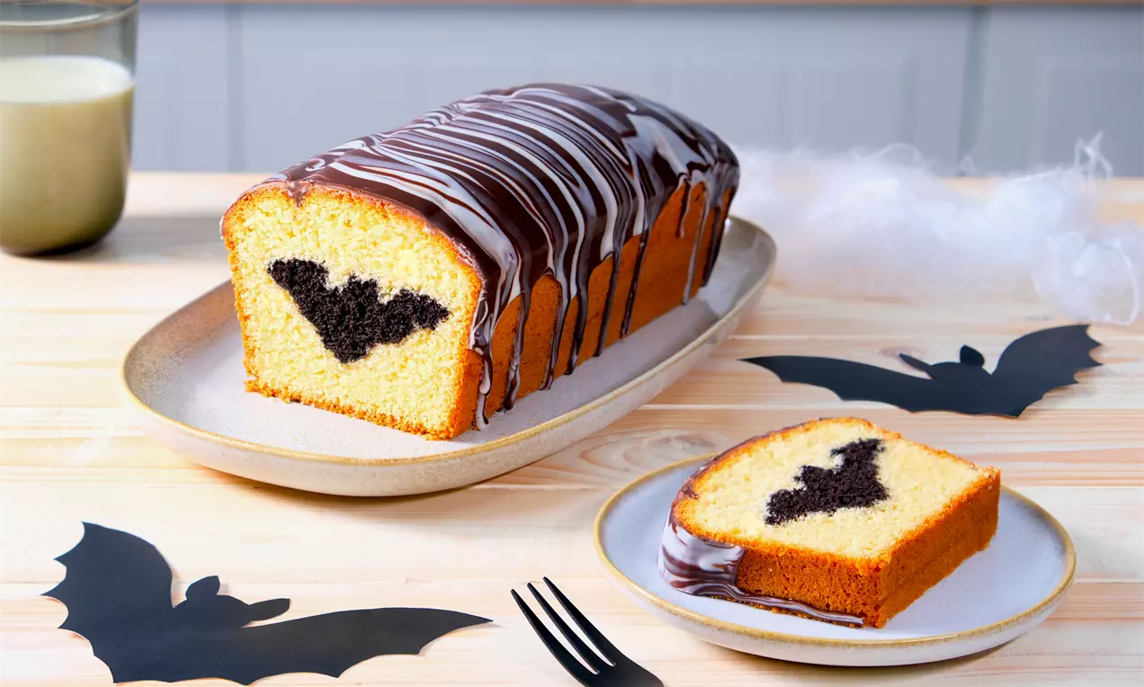 Fledermauskuchen mit hellem Teig und eingebackenen Fledermäusen aus dunklem Teig – kreatives Halloween-Rezept mit Duo-Glasur als süßer Hingucker für jede Party.