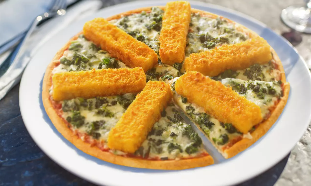 Runde Pizza mit knusprigem Rand, belegt mit goldbraunen Fischstäbchen, grünem Gemüse und geschmolzenem Käse auf weißem Teller