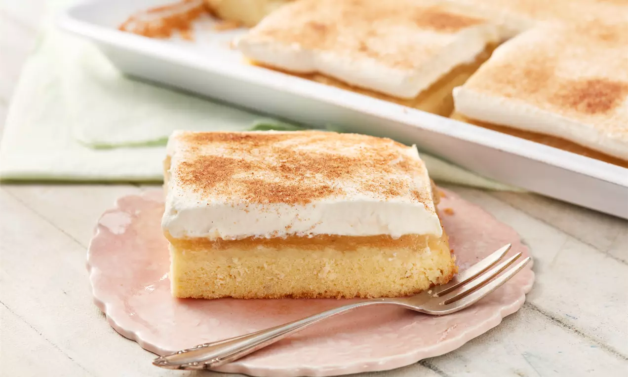 Apfelmuskuchen vom Blech mit goldbrauner Kruste, fruchtigem Apfelmus, sämiger Schmandcreme und leichtem Zimtstaub